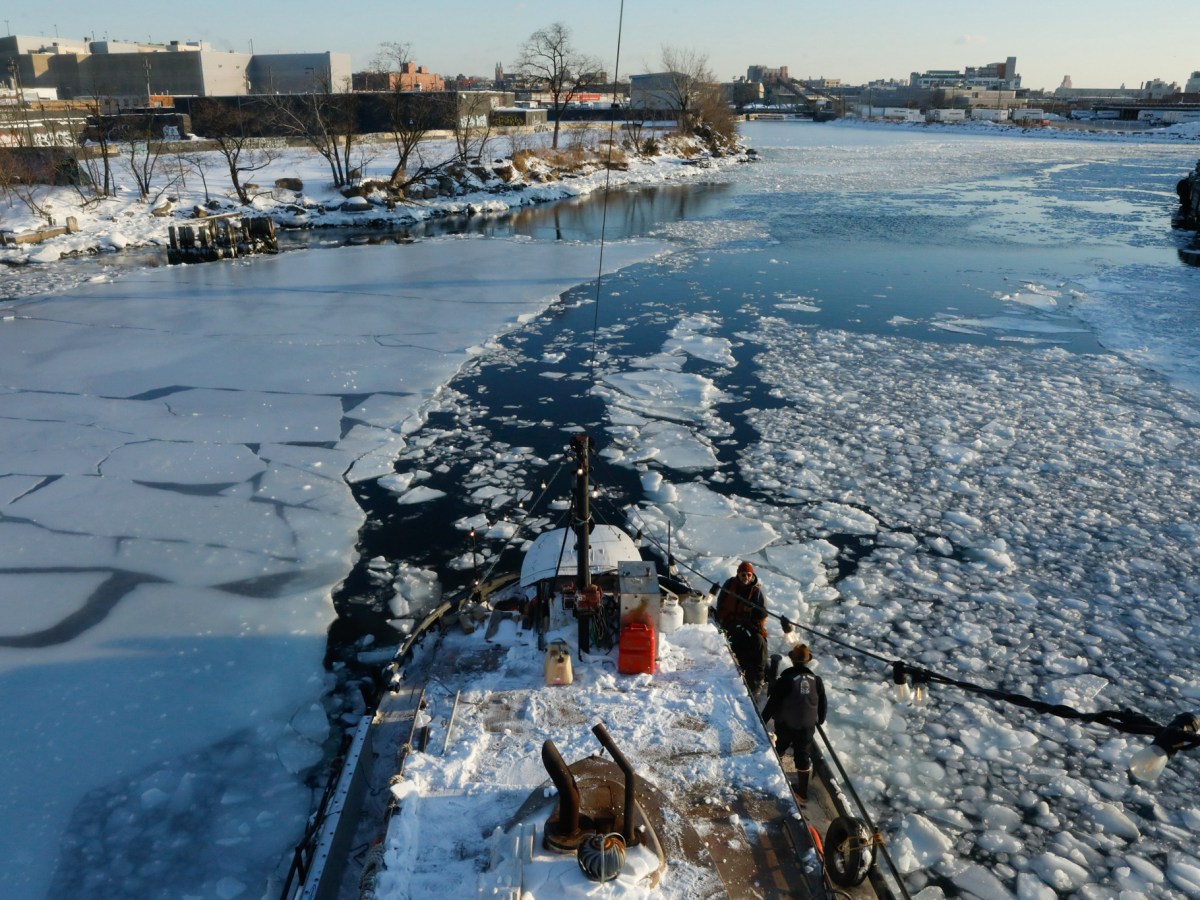 Tugboat operators N.D. Austin and Jean Barberis use the barge to help break up ice in Newtown Creek,