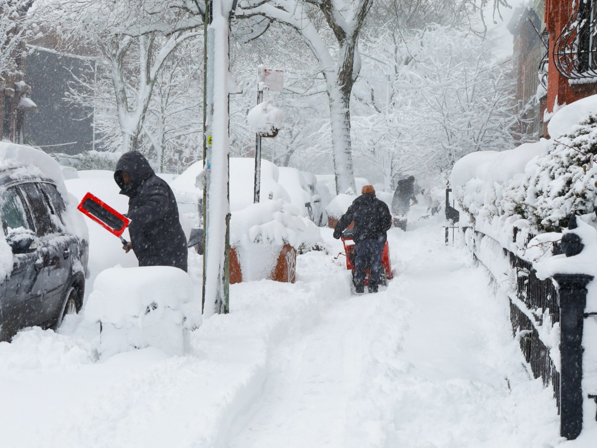 People clear snow in Crown Heights, Brooklyn during a blizzard,