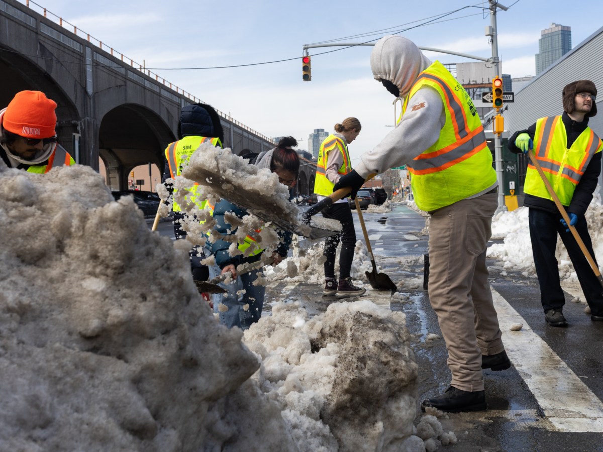 Temporary city workers shovel sidewalks and intersections in Sunnyside