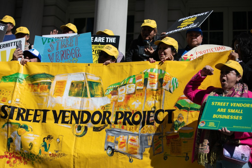 Street vendors join a City Hall rally for newly relaxed enforcement rules,