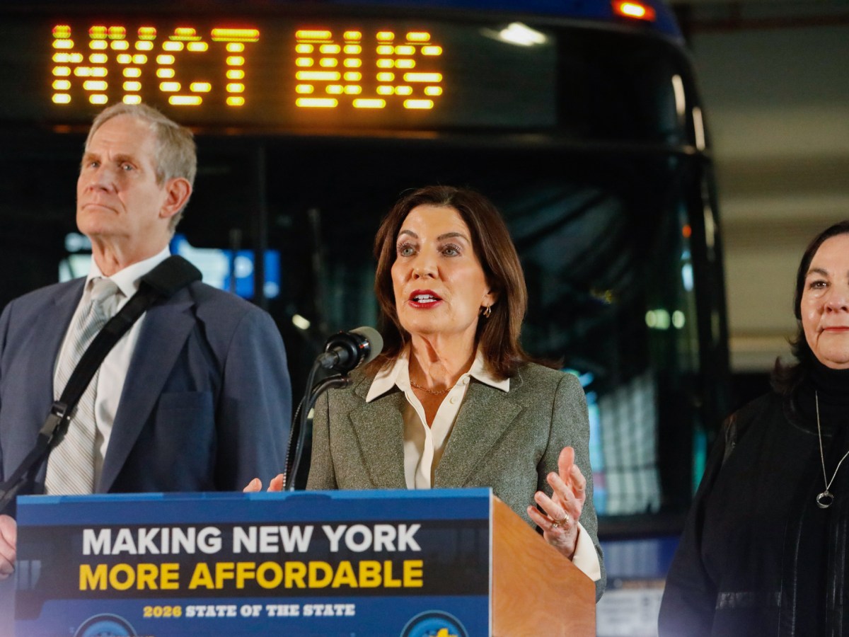 Gov. Kathy Hochul speaks alongside MTA Chair Janno Lieber at a Harlem bus depot about a plan to lower auto insurance, which would save the MTA nearly $50 million annually,