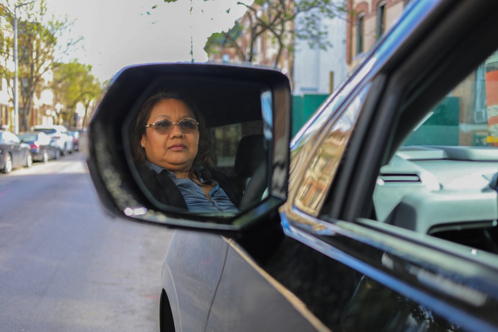 Uber driver Carmen Cruz poses with her vehicle on the east side of Manhattan,