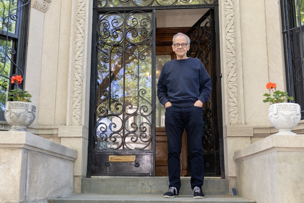 Prospect Lefferts Gardens resident Dean Foster poses in front of his stone townhouse.