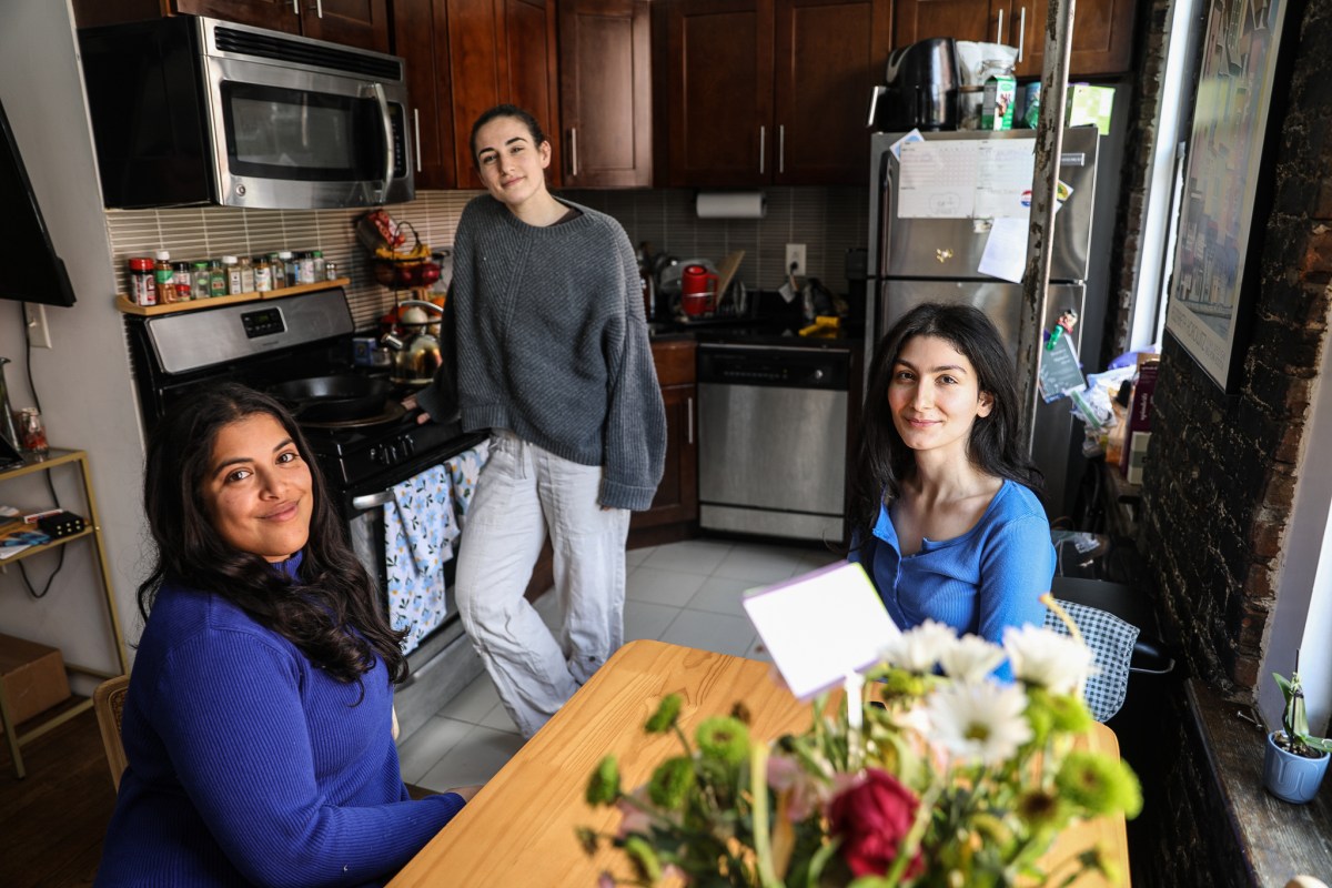 Roommates Feryal Nawaz, left, Carla Orlandi and Parisa sit in their East Village apartment kitchen.