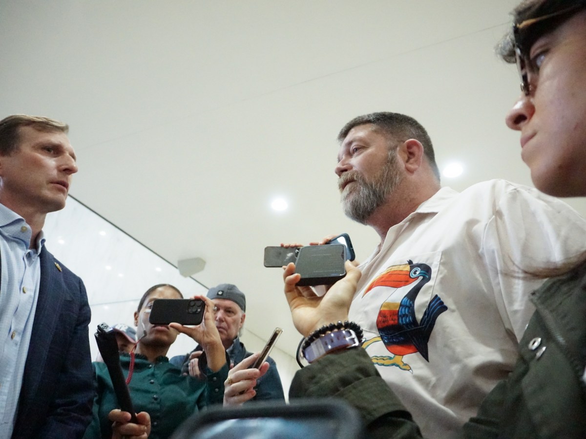 Congressional Rep. Daniel Goldman, left, faces off with William Joyce, deputy director of the New York ICE field office, in the lobby of 26 Federal Plaza in Lower Manhattan