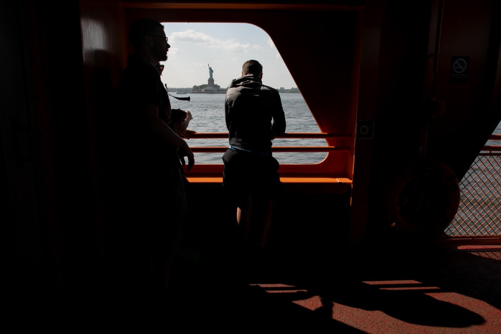 People ride the Staten Island Ferry toward Manhattan.