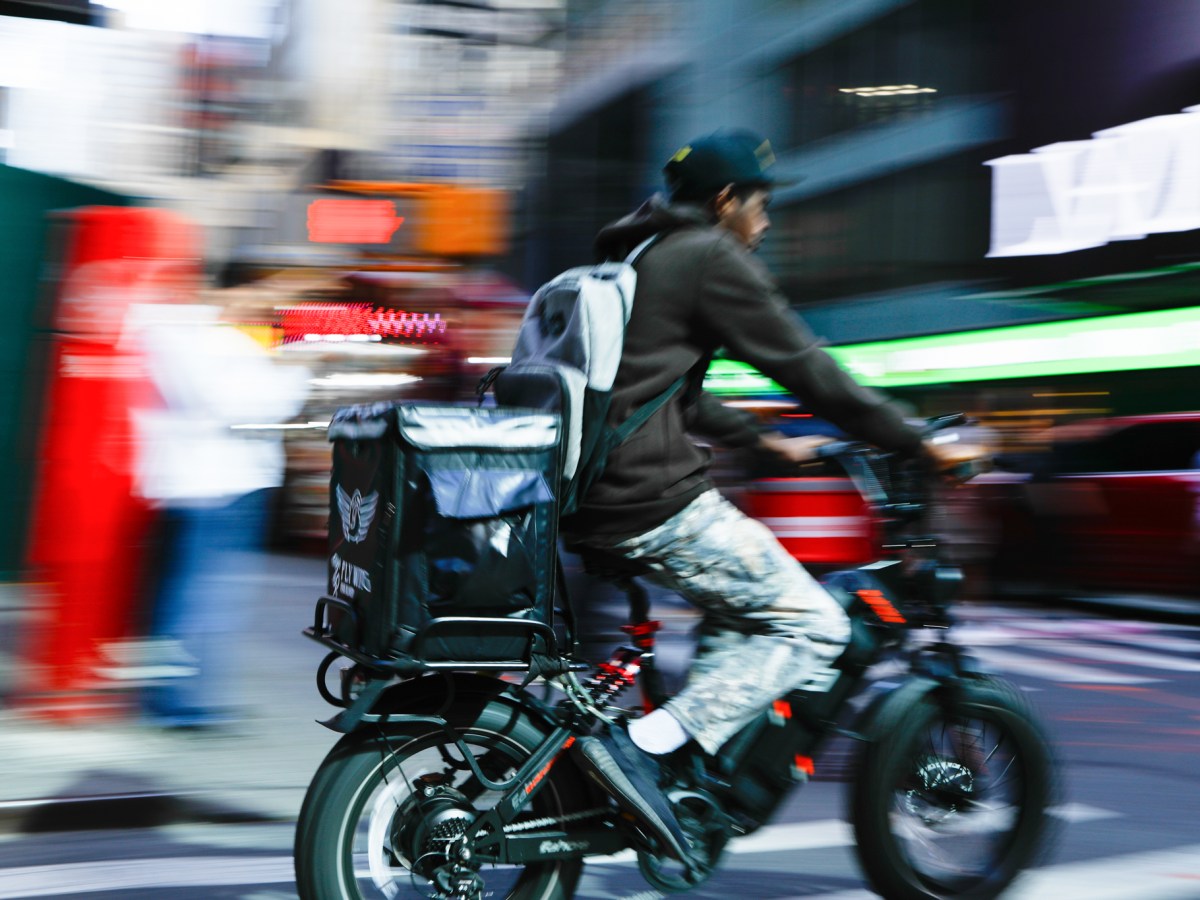 Delivery workers zip through Times Square on e-bikes,