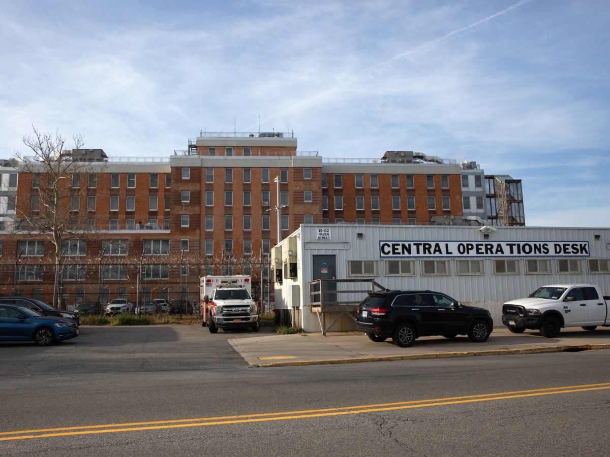 Workers overseeing daily functions on Rikers Island operate outside a jail facility,