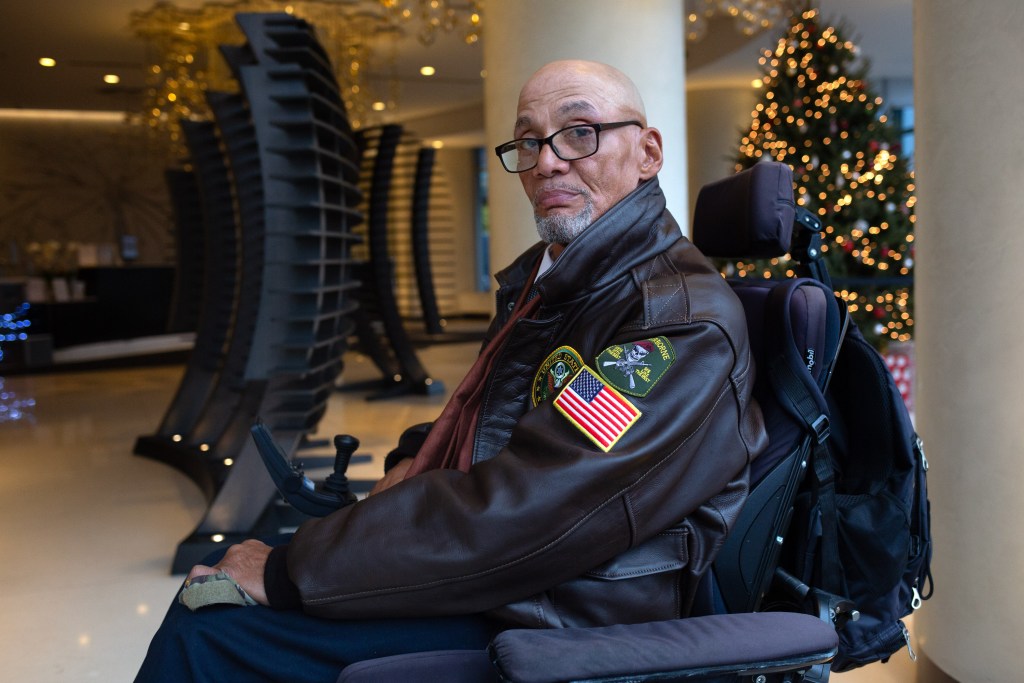Steven Jacks poses for a portrait in the lobby of his Long Island City building while sitting in his wheelchair.