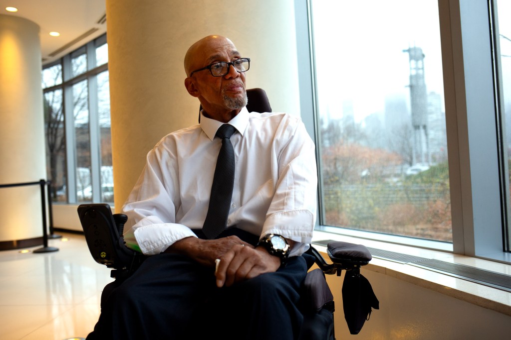 Steven Jacks poses for a portrait in the lobby of his Long Island City building while sitting in his wheelchair.
