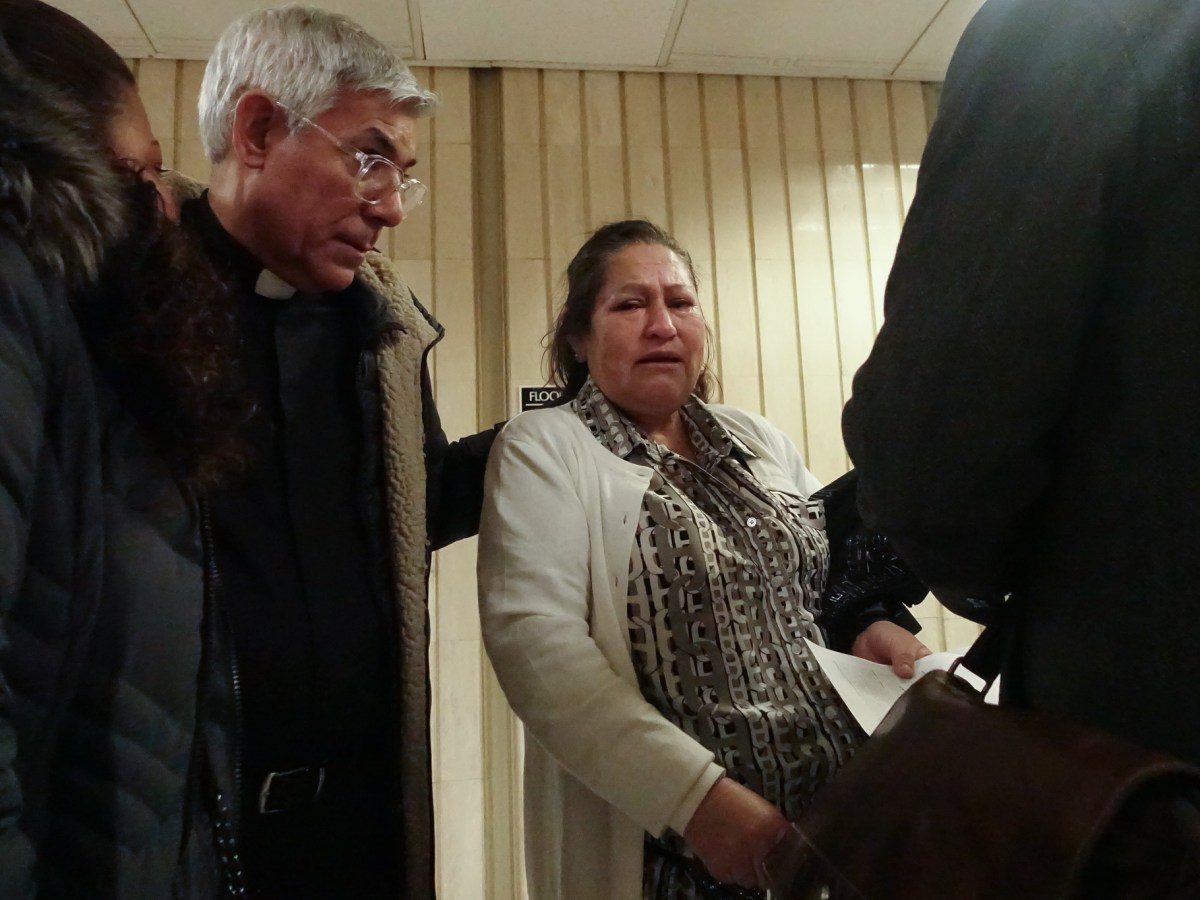 Father Fabian Arias comforts a women leaving immigration court after she was just told the government was moving to deport her to Uganda or Honduras,