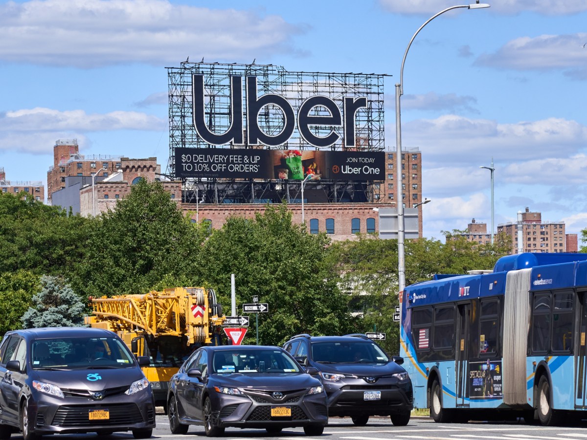 An Uber billboard hovers over Second Avenue and 126th Street in East Harlem.