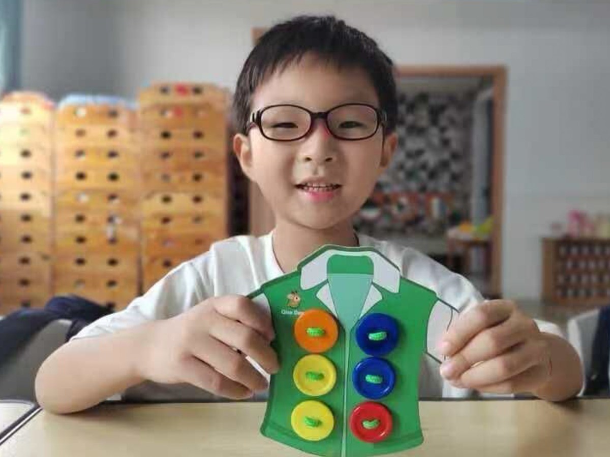 A six-year-old boy plays with a toy in a portrait shot.