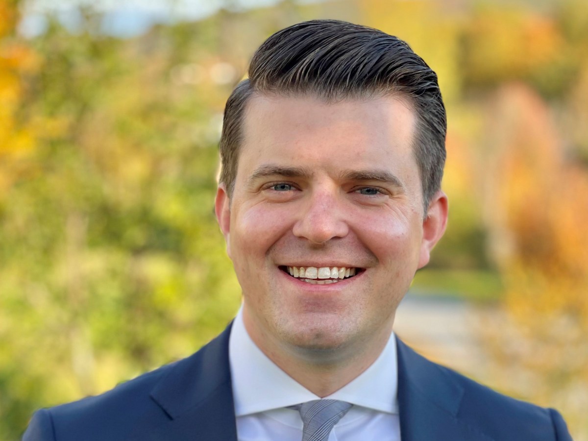 Former Vermont Department of Corrections Commissioner Nicholas Deml smiles in a headshot with fall foliage in the background